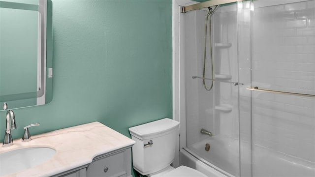 full bathroom featuring enclosed tub / shower combo, vanity, and toilet