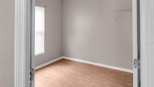 unfurnished room with light wood-type flooring and baseboards