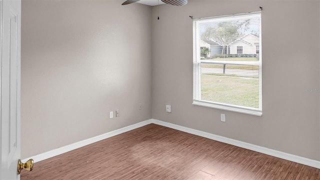 spare room with ceiling fan, wood finished floors, and baseboards