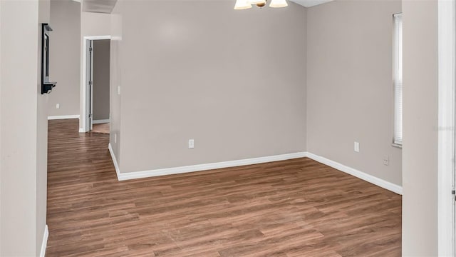 empty room featuring dark wood-style floors and baseboards