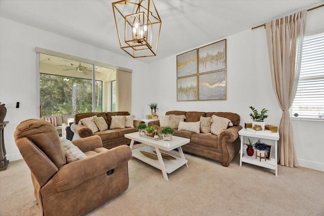 living room with carpet floors and ceiling fan with notable chandelier