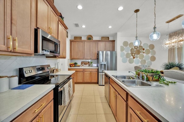 kitchen featuring appliances with stainless steel finishes, sink, light tile patterned flooring, decorative light fixtures, and tasteful backsplash