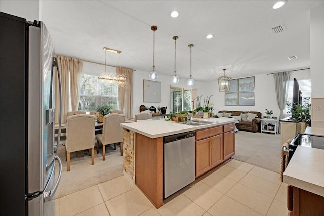 kitchen featuring a center island with sink, an inviting chandelier, stainless steel appliances, and sink