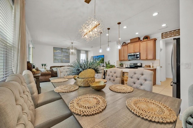 dining space featuring light tile patterned floors and an inviting chandelier