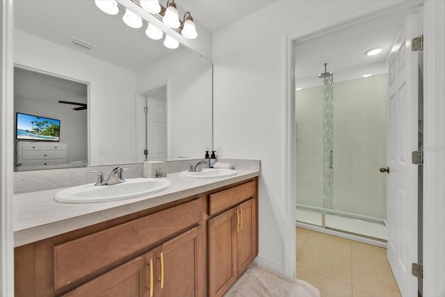 bathroom featuring tile patterned floors, ceiling fan, vanity, and a shower with door