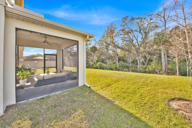 view of yard featuring ceiling fan and a sunroom