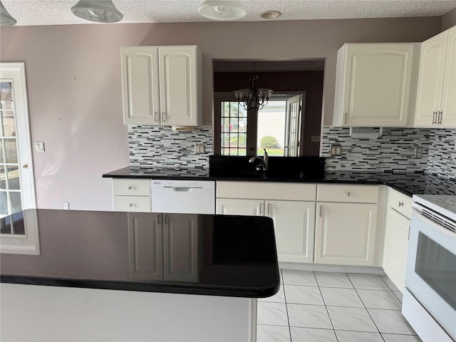 kitchen featuring white appliances, white cabinetry, a notable chandelier, a textured ceiling, and decorative backsplash