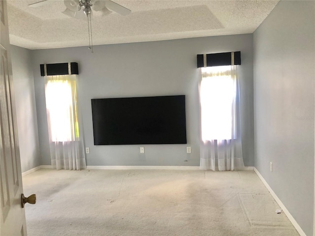 empty room with a healthy amount of sunlight, a textured ceiling, and carpet flooring