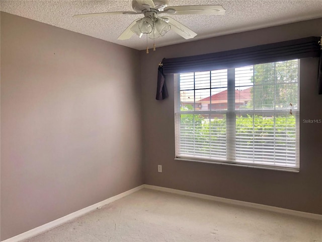 unfurnished room with ceiling fan, carpet, and a textured ceiling