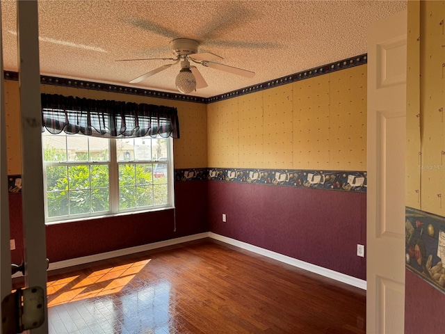 spare room featuring ceiling fan, wood-type flooring, and a textured ceiling