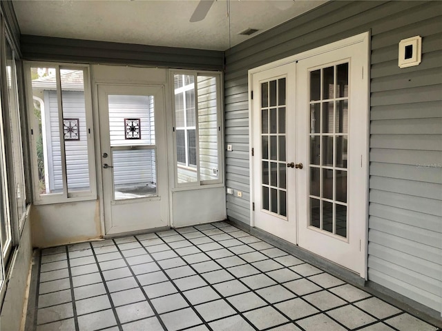 unfurnished sunroom with ceiling fan and french doors