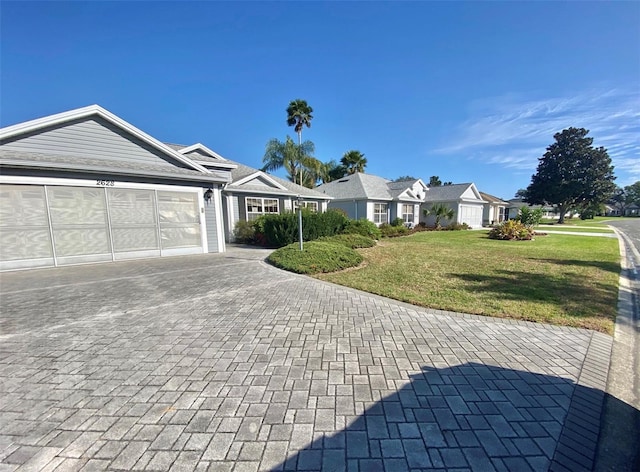 single story home with a garage and a front lawn