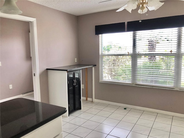 2628 Caribe Dr, The Villages, FL 32162 - kitchen featuring ceiling fan, a textured ceiling, dark countertops, and healthy amount of natural light