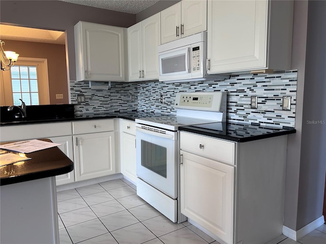 2628 Caribe Dr, The Villages, FL 32162 - kitchen with white appliances, dark countertops, tasteful backsplash, and white cabinets