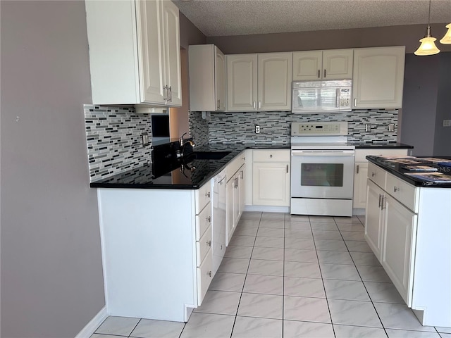 2628 Caribe Dr, The Villages, FL 32162 - kitchen with white appliances, dark countertops, tasteful backsplash, white cabinetry, and a textured ceiling