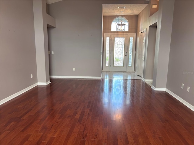 2628 Caribe Dr, The Villages, FL 32162 - foyer with a chandelier, dark wood-type flooring, and a high ceiling