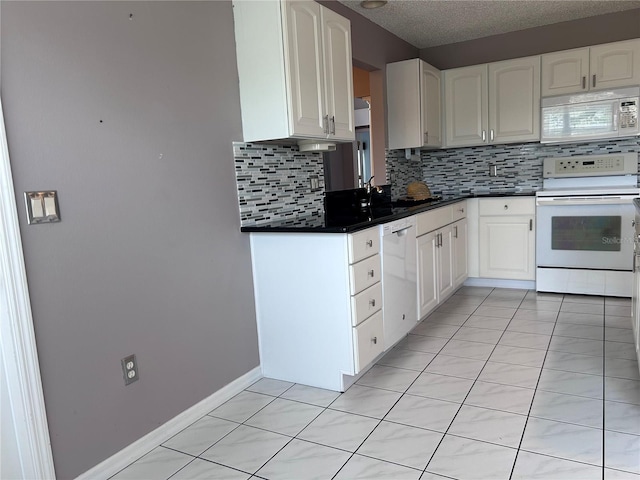 2628 Caribe Dr, The Villages, FL 32162 - kitchen with white appliances, decorative backsplash, white cabinetry, and a textured ceiling