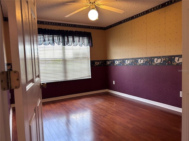 2628 Caribe Dr, The Villages, FL 32162 - empty room with wood finished floors, a ceiling fan, a textured ceiling, and wallpapered walls