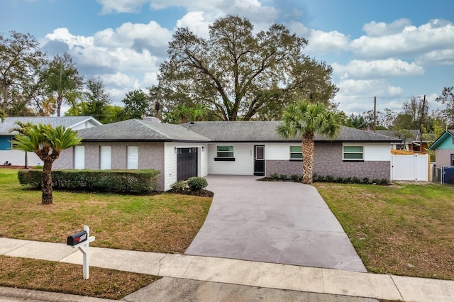 single story home featuring an attached garage, driveway, roof with shingles, a chimney, and a front yard