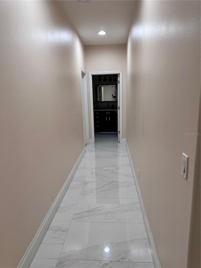 corridor with recessed lighting, marble finish floor, and baseboards