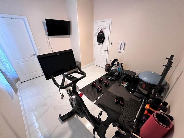 exercise area featuring marble finish floor