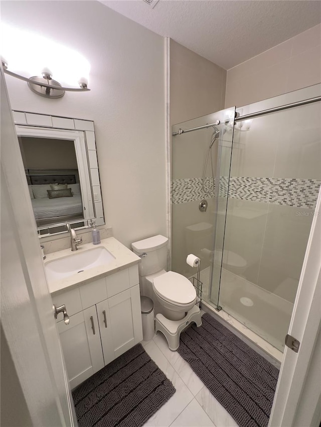 bathroom with a textured ceiling, a stall shower, vanity, and toilet