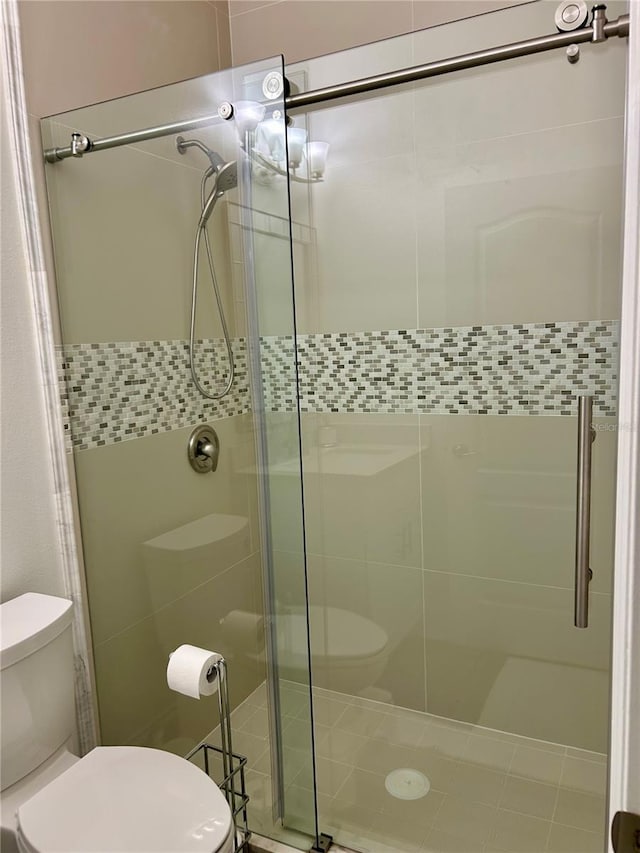 full bath featuring a stall shower and toilet