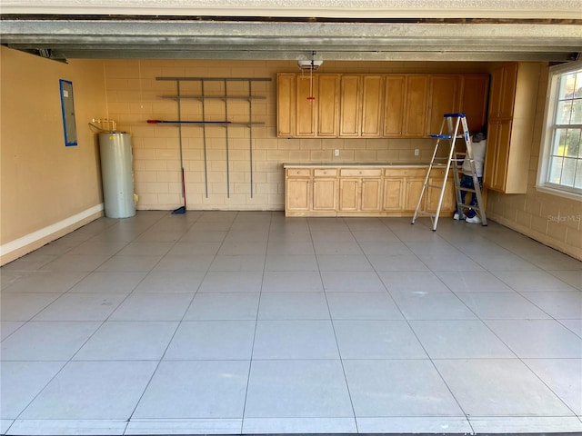 garage with gas water heater, electric panel, and a garage door opener