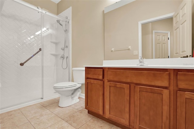 bathroom featuring tile patterned floors, toilet, vanity, and a shower with door