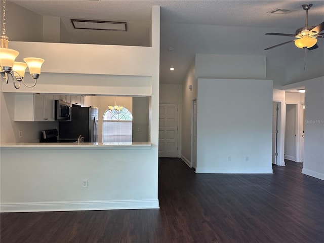 kitchen with appliances with stainless steel finishes, white cabinets, ceiling fan with notable chandelier, dark hardwood / wood-style floors, and kitchen peninsula