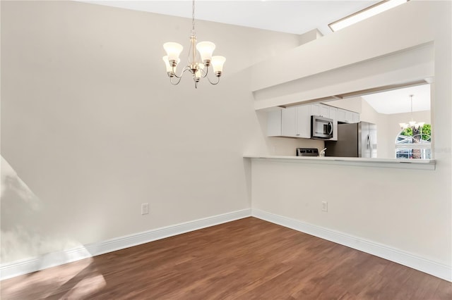 unfurnished dining area featuring lofted ceiling, baseboards, dark wood-style flooring, and a chandelier