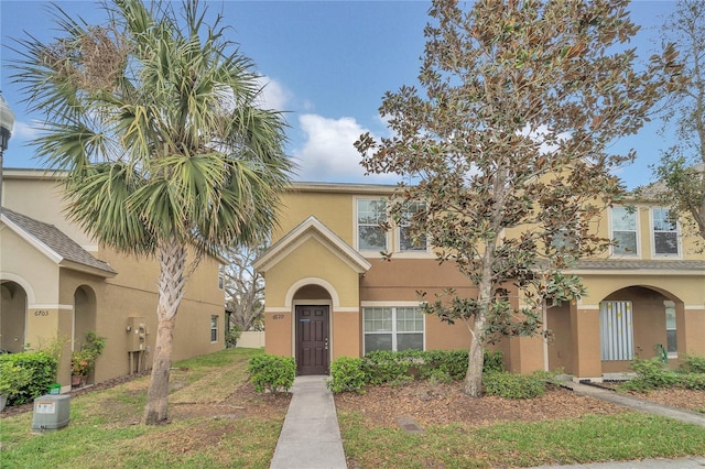 view of property featuring a front yard and stucco siding