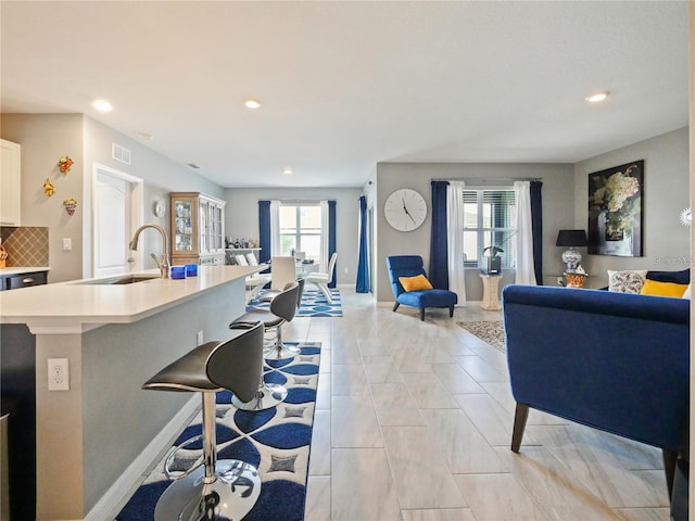 tiled living room with plenty of natural light and sink