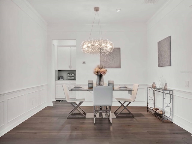 dining space featuring dark wood-type flooring, crown molding, and a notable chandelier