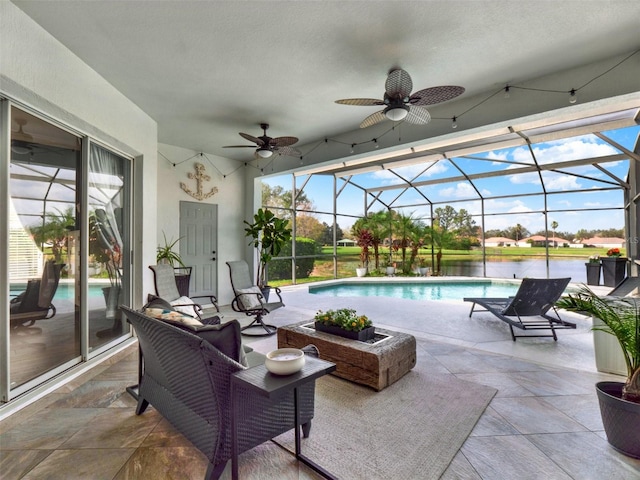 pool with a water view, glass enclosure, ceiling fan, and a patio area