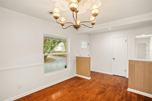 unfurnished dining area with a notable chandelier, ornamental molding, baseboards, and wood finished floors