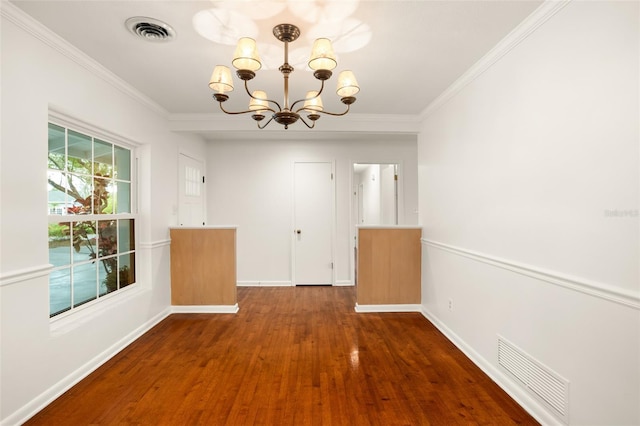 unfurnished dining area with visible vents, wood finished floors, an inviting chandelier, and ornamental molding