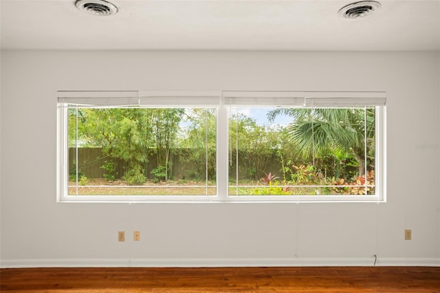 unfurnished room with a healthy amount of sunlight and visible vents