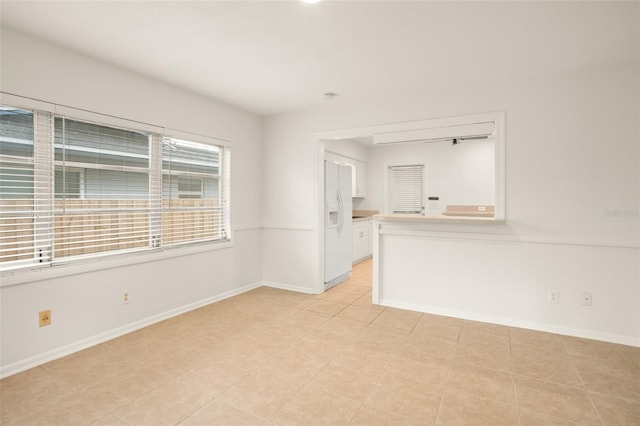 empty room featuring light tile patterned floors and baseboards