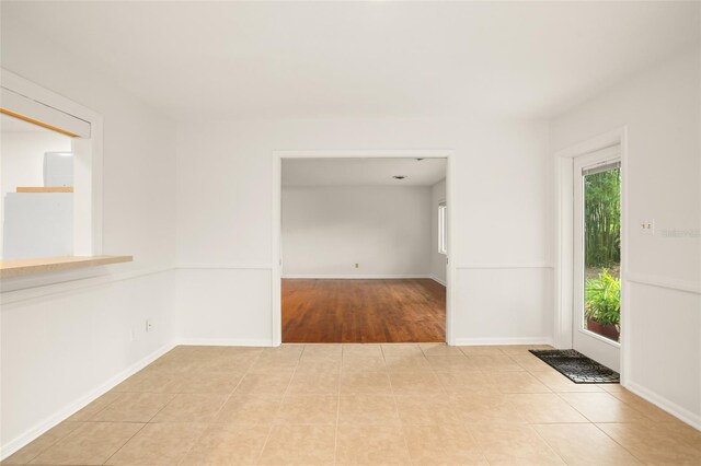 tiled spare room featuring baseboards