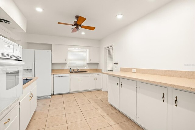 kitchen with recessed lighting, white appliances, white cabinets, and a sink