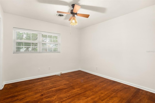 empty room with visible vents, ceiling fan, baseboards, and wood finished floors