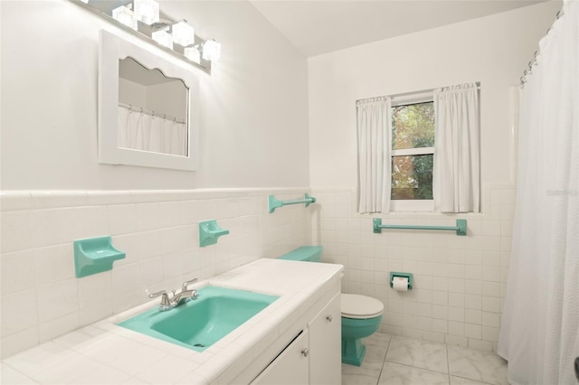 full bath with vanity, toilet, and a wainscoted wall