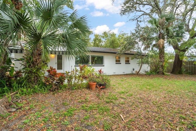 rear view of property with a yard and fence