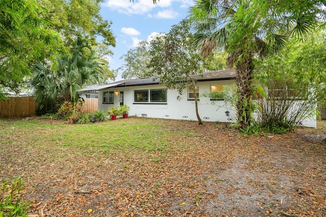 back of property with crawl space, a yard, and fence