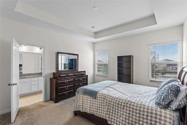 carpeted bedroom with multiple windows, a textured ceiling, and a tray ceiling