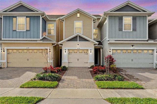 townhome / multi-family property featuring driveway, a garage, and board and batten siding