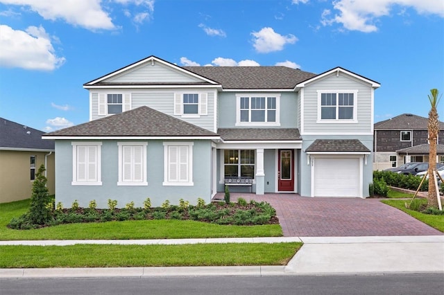 view of front of property featuring a garage and a front lawn