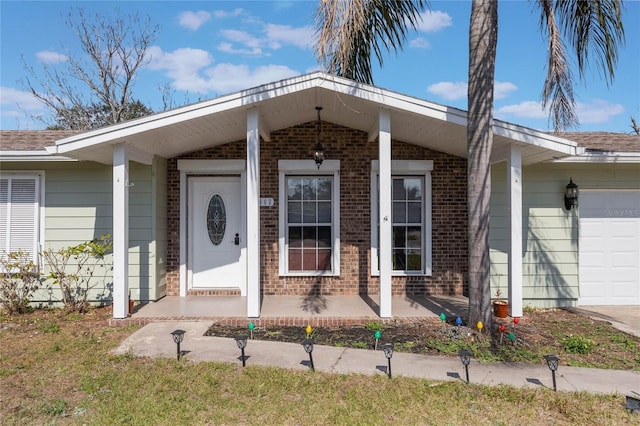 view of exterior entry featuring a garage and a lawn