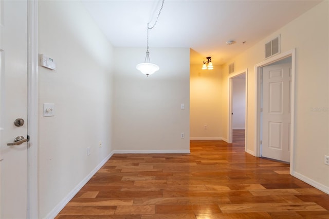 unfurnished dining area with baseboards, visible vents, and light wood-type flooring